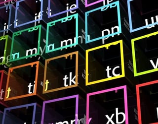 Des cubes transparents aux bordures colorées affichent des combinaisons de lettres blanches en perspective sur un fond sombre.