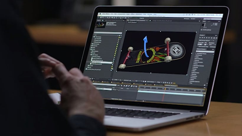 Personne utilisant un logiciel de modélisation 3D sur un ordinateur portable pour animer un skateboard coloré.